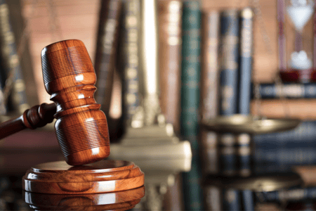 wooden gavel with books behind it