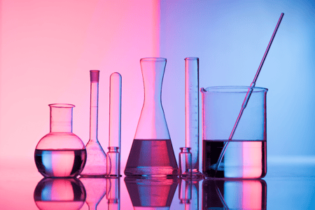 beakers and test tubes with pink and purple background